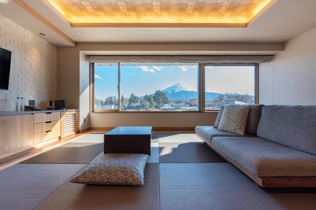 Una sala de estar con un sofá y una ventana grande. en Oike Hotel, en Fujikawaguchiko