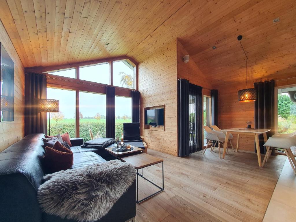 a living room with a couch and a table at Schwarzes Holzferienhaus mit Sauna -- FELDRAIN -- an der Ostsee, Zierow bei Wismar, 4-6 Personen in Zierow