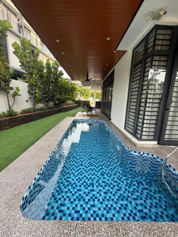 a swimming pool with blue tiles in a house at The Garden Twelve Homestay in Putrajaya