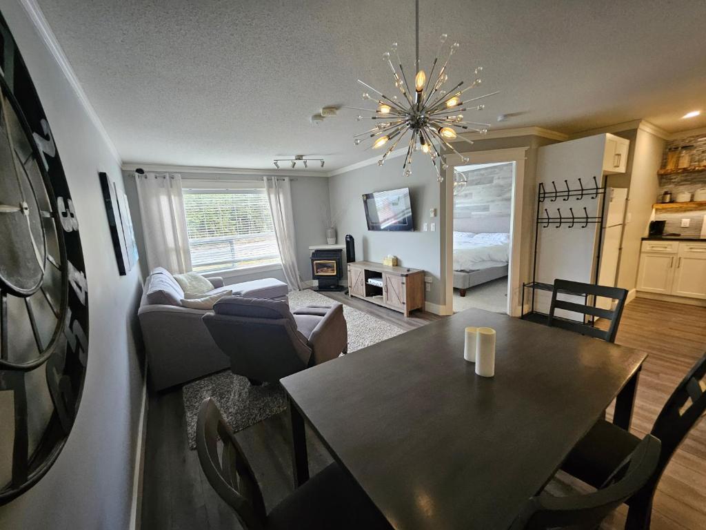 ein Wohnzimmer mit einem Tisch und ein Esszimmer in der Unterkunft White-Tail Hollow - 309 - 1105 Henry Rd in Courtenay