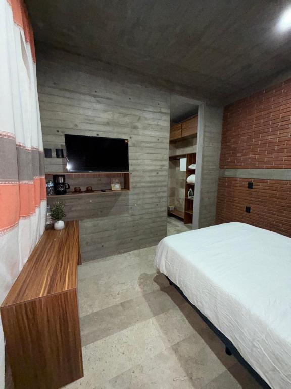 ein Schlafzimmer mit Bett und Flachbildfernseher in der Unterkunft Casa Don Tacho in Cedro