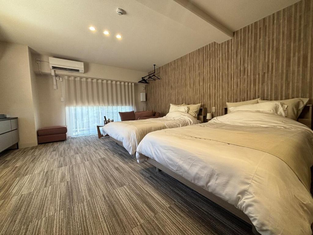 a hotel room with two beds in a room at プリンスプラージュ沖縄301 in Onna