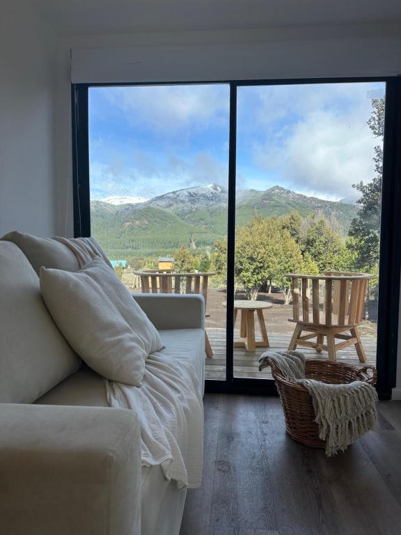 Una sala de estar con un sofá y una ventana grande. en Nina apart Meliquina, en San Martín de los Andes