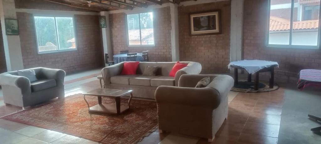 a living room with couches and a table and windows at Cozy Rural House in Apata - Jauja 