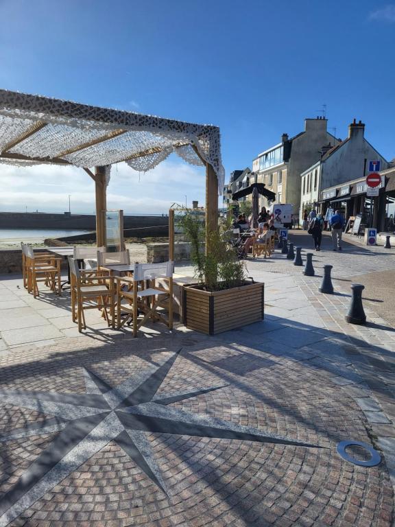 d'une terrasse avec des tables et des chaises sur la plage. dans l'établissement La Belle vue, à Ploemeur