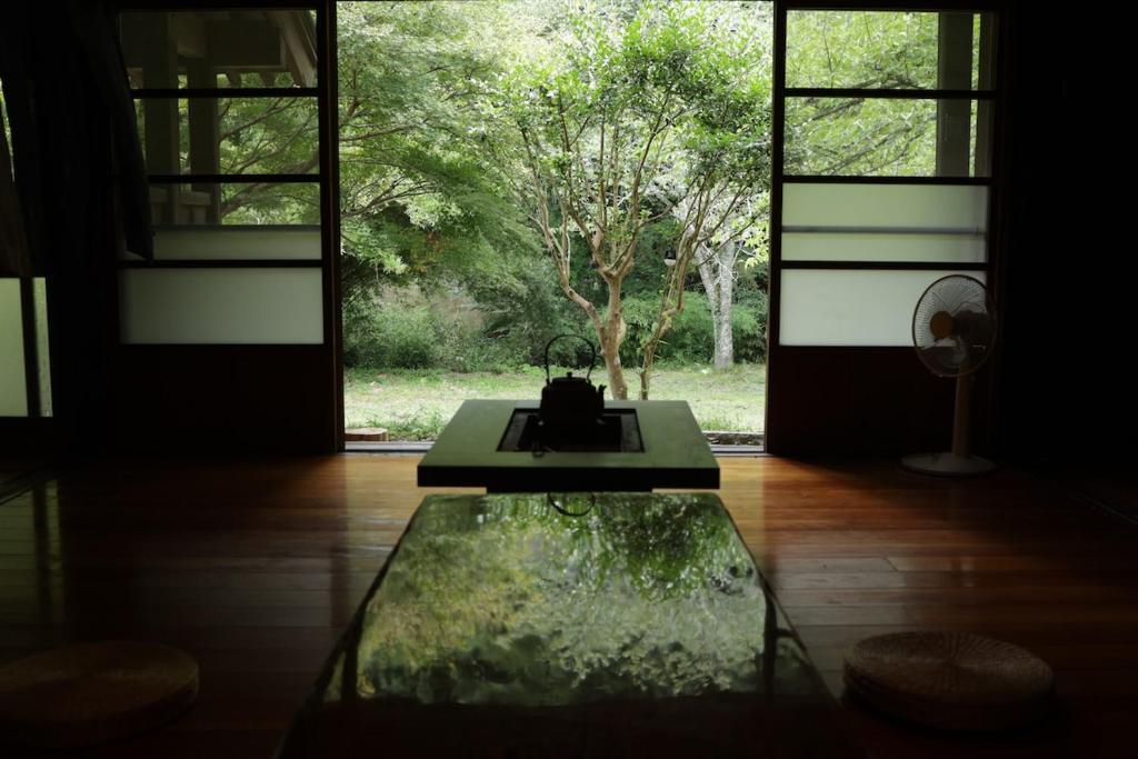 een kamer met een glazen tafel en een raam bij BoBuchi in Ichihara