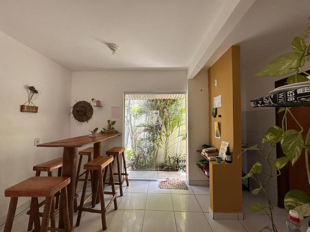 a kitchen with a table and stools in a room at Pipa Guest House in Pipa