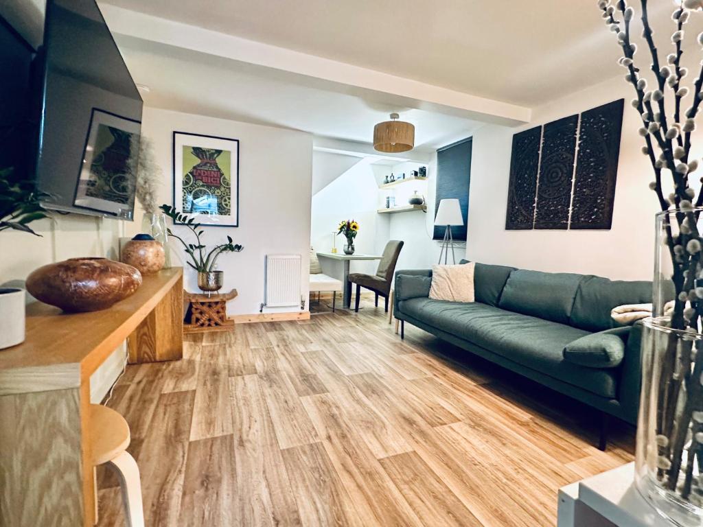 a living room with a couch and a table at Peaceful and Stylish Garden Flat Close to Transport and City Centre in Glasgow