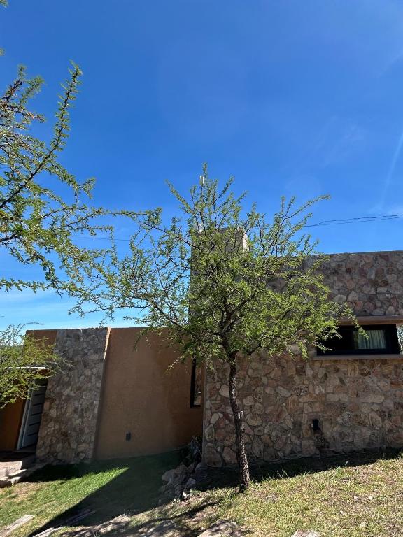 拉布拉斯Refugio de las Nubes的一座石头建筑,前面有一棵树