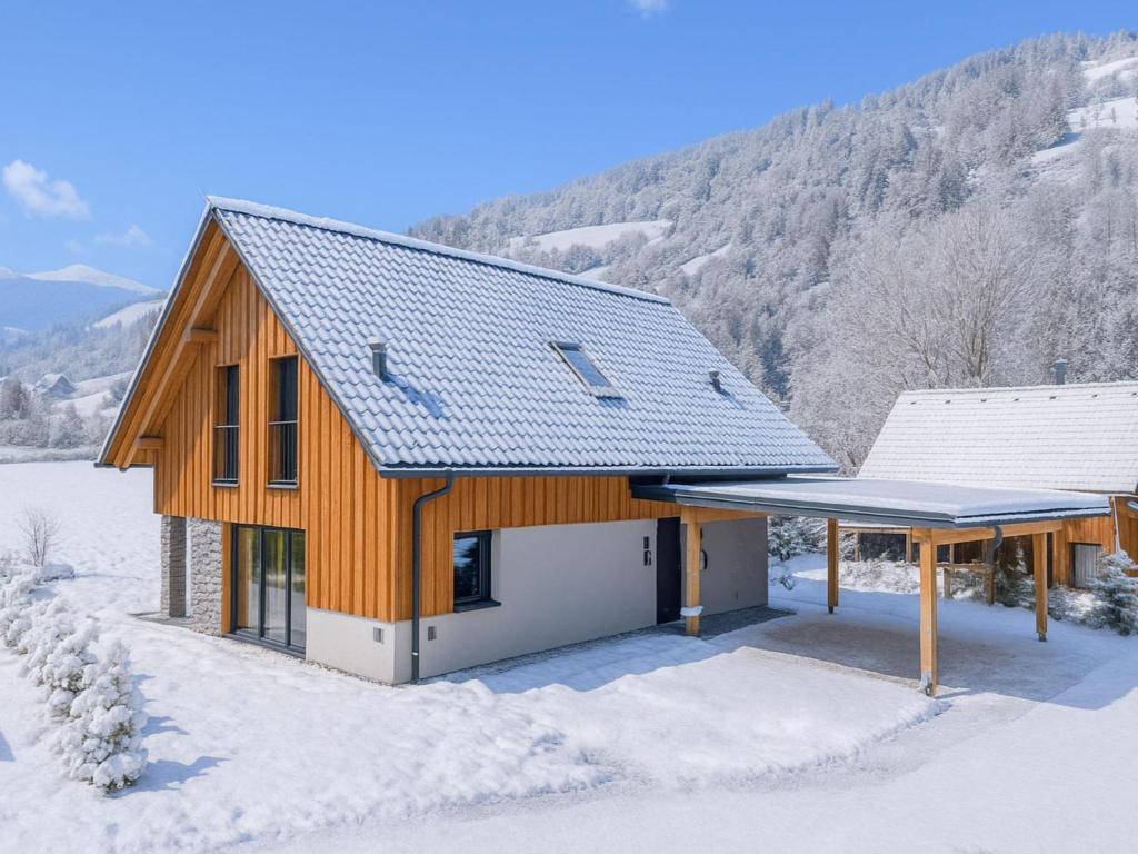 a wooden house with a roof in the snow at Mountain Chalet Alpinchique in Sankt Lorenzen ob Murau