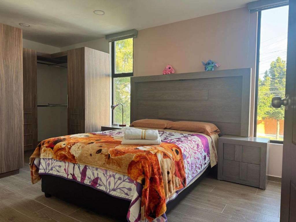 a bedroom with a bed and a large window at Hogar Periférico Sur in Lomas de Angelopolis