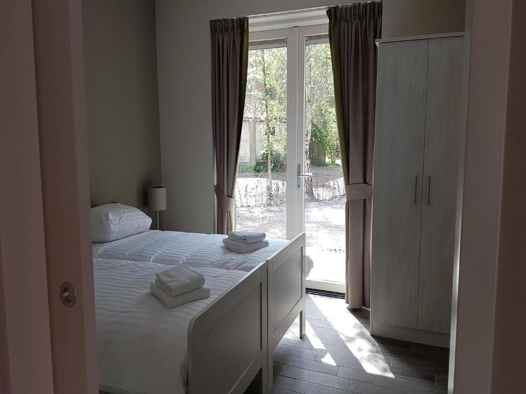 アルメンにあるCozy villa in the middle of the Achterhoekのベッドと大きな窓のある寝室