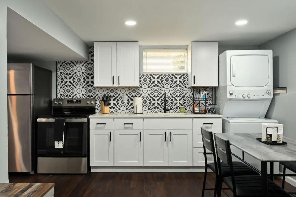 a kitchen with white cabinets and a table with chairs at 2BR Home KC Stadiums Great Location I-70 in Blue Springs