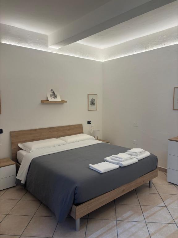 a bedroom with a large bed with towels on it at SottoSopra Apartments - In centro a piedi in Ferrara