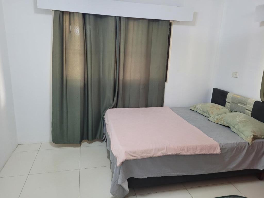 a bedroom with a bed and a window with at Shalom Home Stay in Nadi International Airport