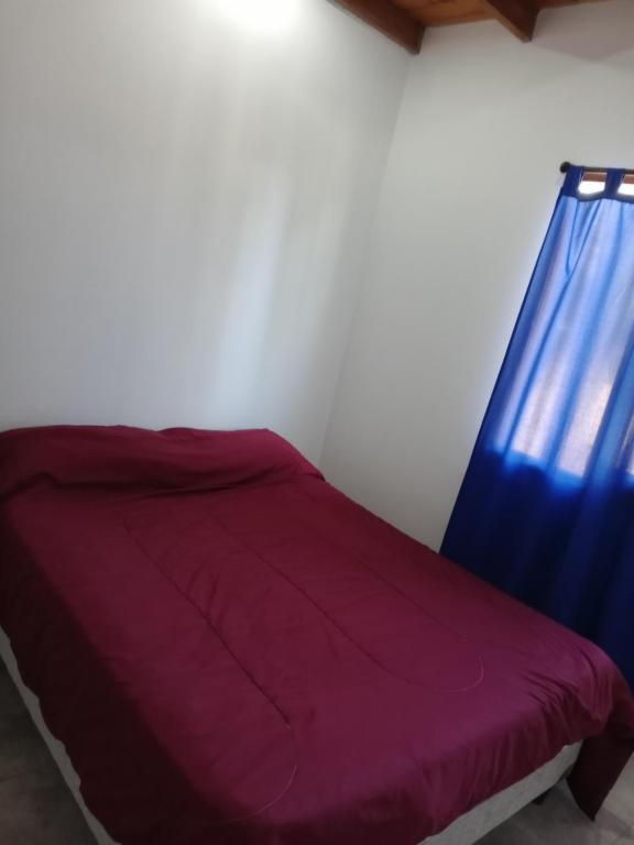 a bedroom with a purple bed with a blue curtain at Mí esquina departamentos familiares in Villa Gesell