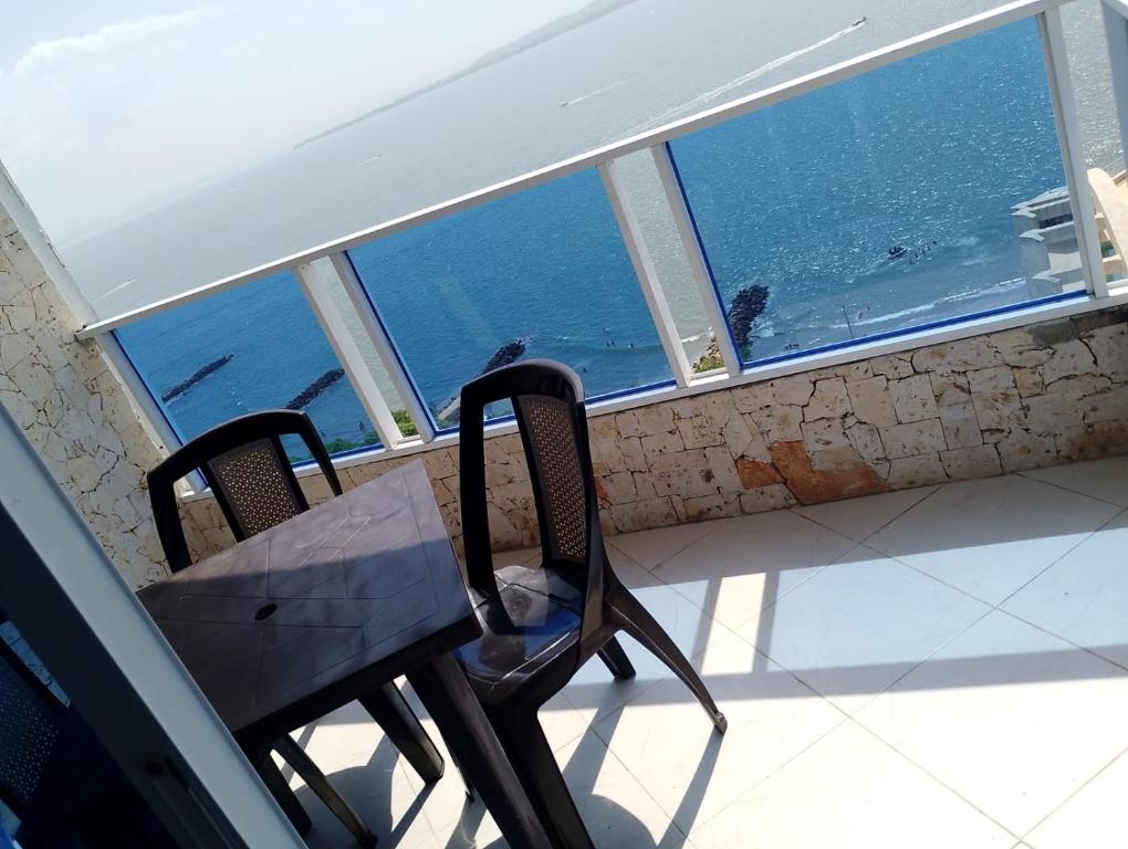 a table and chairs on a balcony with a view of the ocean at Apartamento cerca Bocagrande in Cartagena de Indias