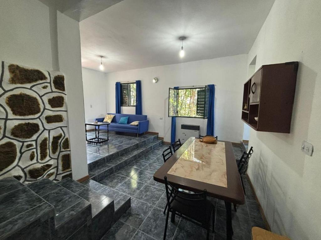 a living room with a table and a blue couch at Refugio Blue Hill in Villa Cerro Azul