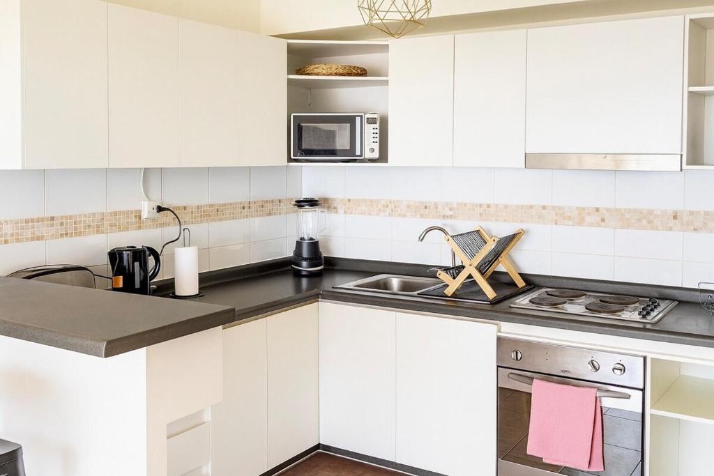 拉塞雷纳Apartment steps from the beach, 3D-2B and elevator的带水槽和微波炉的白色厨房