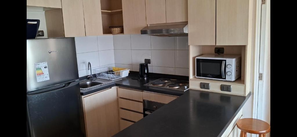 une cuisine avec un micro-ondes et un plan de travail dans l'établissement Depto Puertas del Mar La Serena, à La Serena