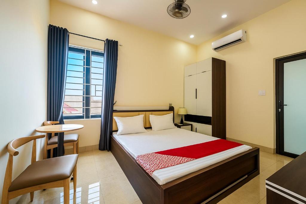 a bedroom with a bed and a chair and a window at Dũng Quyến Homestay in Danang