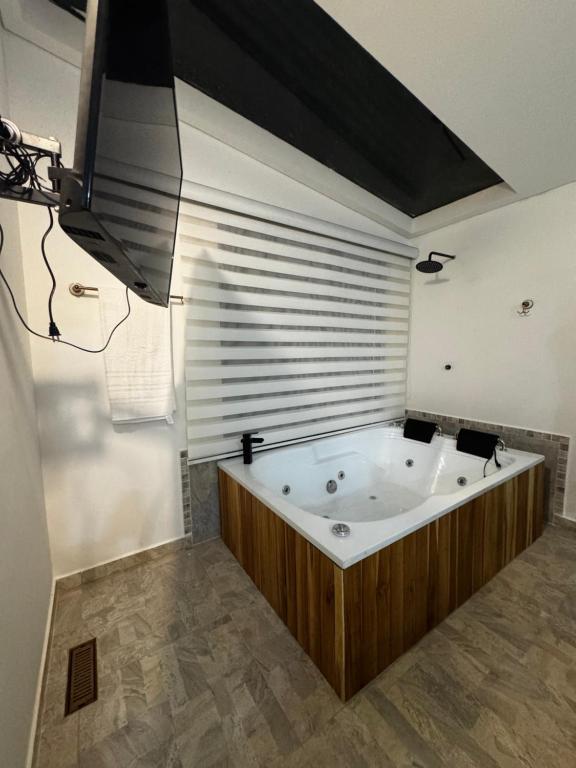 a large bath tub in a bathroom with a large window at Sempiterno- la cabaña Whispering Wind in La Vega