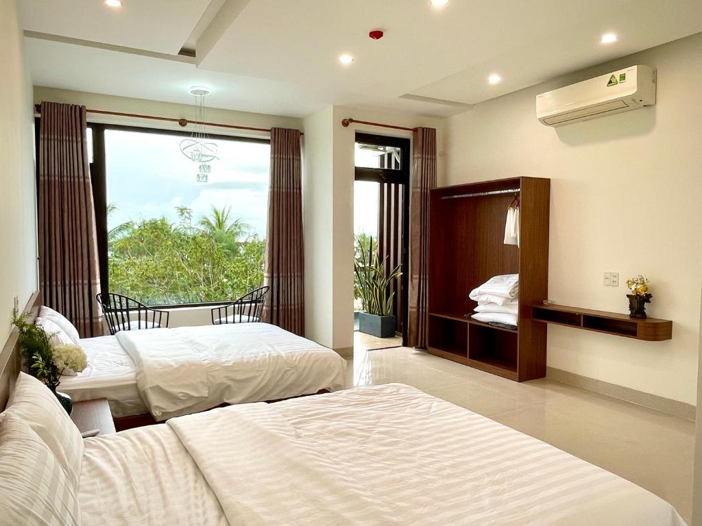 a bedroom with two beds and a large window at Aura Beachfront Hotel - Apartment in Da Nang
