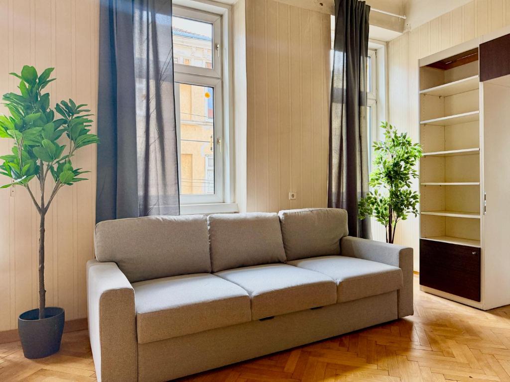a living room with a couch and a window at Spacious Classical Style Apartment in Vienna