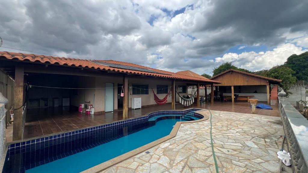 a house with a swimming pool in front of it at Your private paradise 4 suites in Hidrolândia GO in Hidrolândia