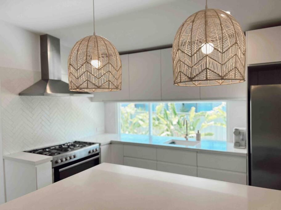 een keuken met 2 hanglampen en een aanrecht bij The Summer House in Long Jetty