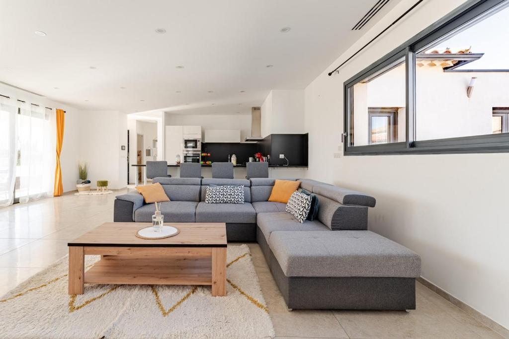 a living room with a couch and a table at L'Oasis de Saint-Quentin in Saint-Quentin-la-Poterie