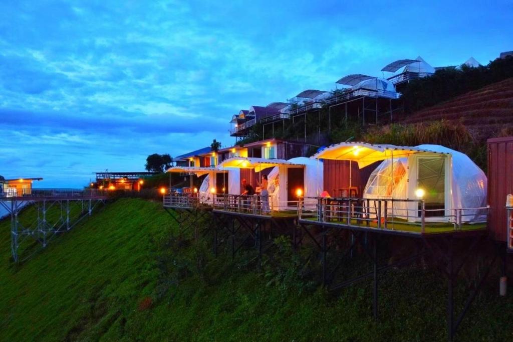 a row of tents sitting on a hill at night at ภูชวนหลง ม่อนแจ่ม in Chiang Mai