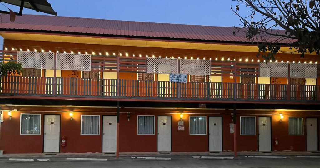 un edificio rosso con un balcone e porte bianche di Panngernpanthong inn resort a Ban Nong Chaeng