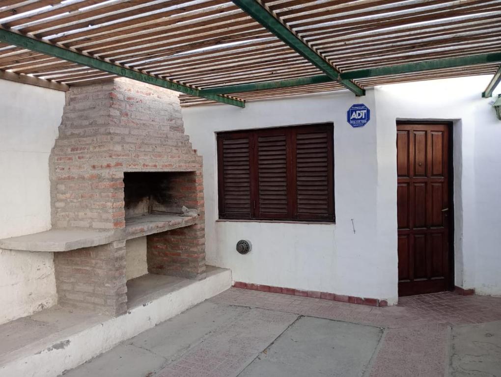 a brick fireplace in a building with a wooden ceiling at Ruca Melin in Las Grutas