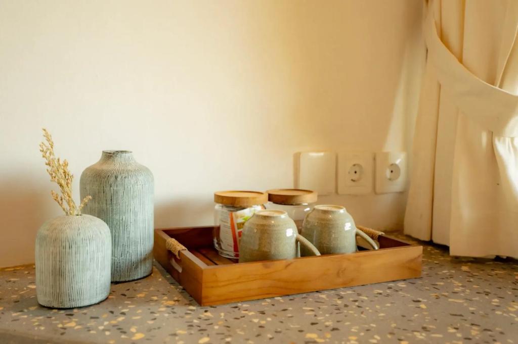 a wooden tray with jars and a vase on a table at Elysian Cove - One Bedroom Villa in Sekongkang Bawa