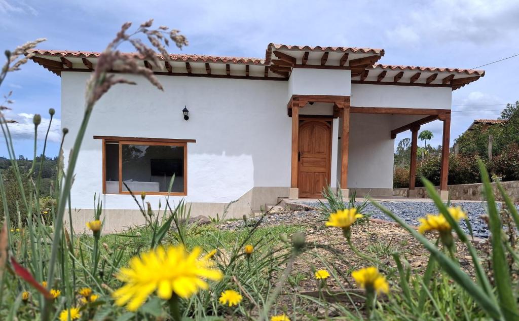 a house with a garden with flowers in front of it at Chalet Villa Serena in Villa de Leyva