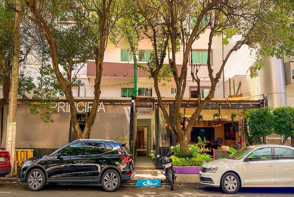 two cars parked in a parking lot in front of a building at Hotel Estancias VIVE MX wtc CDMX, Trademark by Wyndham in Mexico City