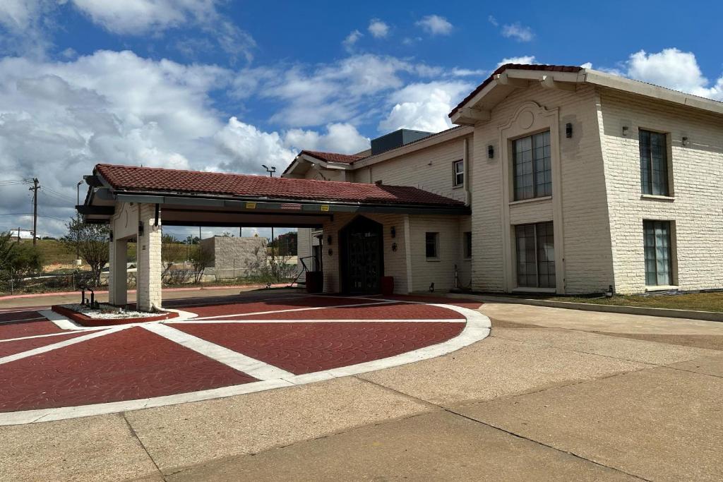 a large building with a red road in front of it at Baymont by Wyndham Nacogdoches Near University in Nacogdoches