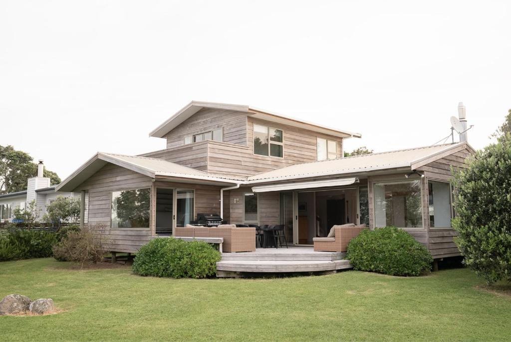 a large house with a porch and a yard at Tranquil Waterfront Getaway - Point Wells in Omaha