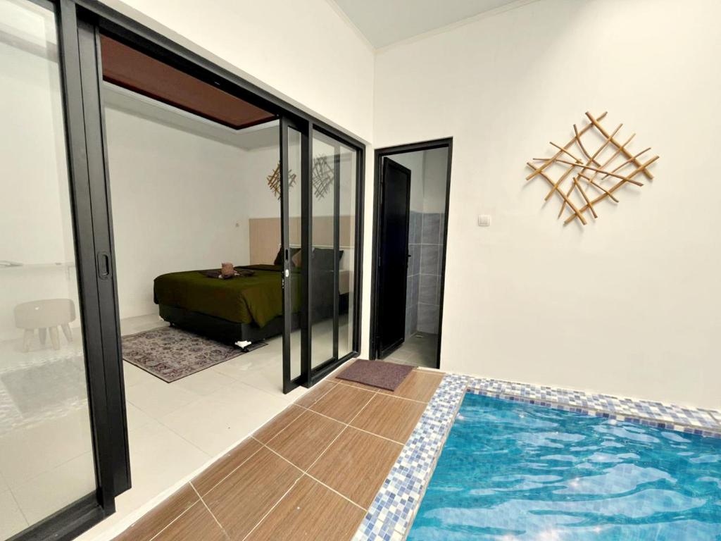 a room with a swimming pool and a bedroom at Prama Peaceful Living Villa in Ngaglik