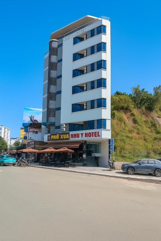 a large building with a car parked in front of it at Như Ý Hotel Hà Giang in Ha Giang