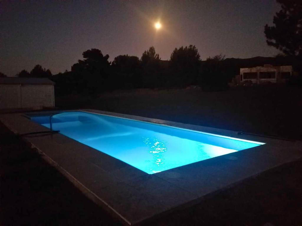 Villa Los MolinosBosquemolinos的夜间游泳池,月亮为背景