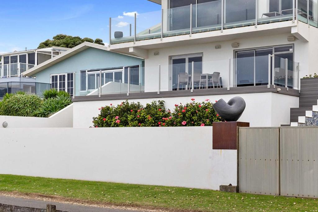 a house with a black heart on the side of it at Beachfront Breeze - sea views for days in New Plymouth