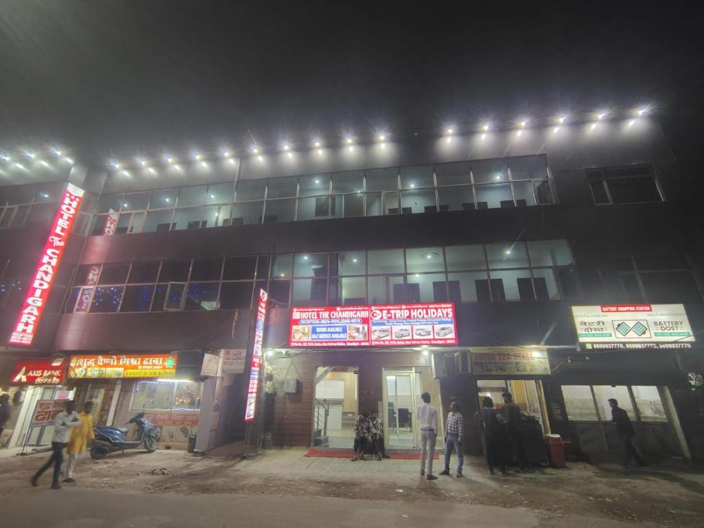 un grupo de personas de pie fuera de un edificio por la noche en Hotel the Chandigarh, en Chandīgarh
