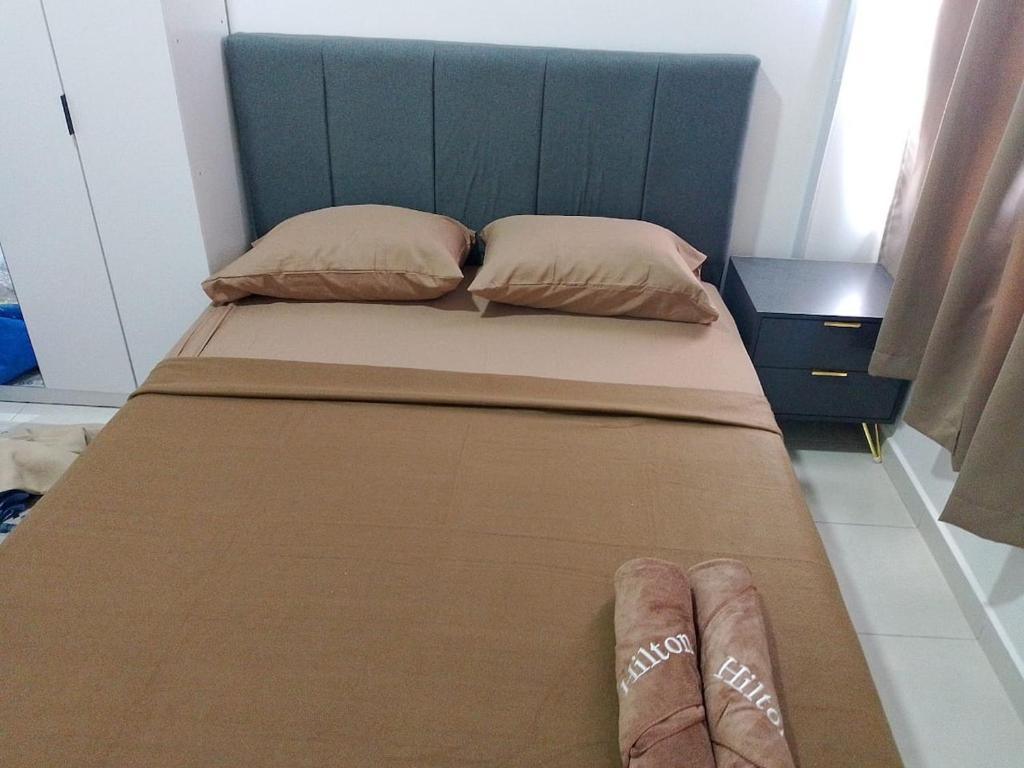 a bed with two pillows and a blue headboard at The Duta Loft in Bandar Puncak Alam