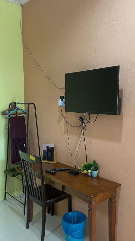 a wooden desk with a computer monitor on a wall at Teratak Atok Ajib in Pantai Cenang
