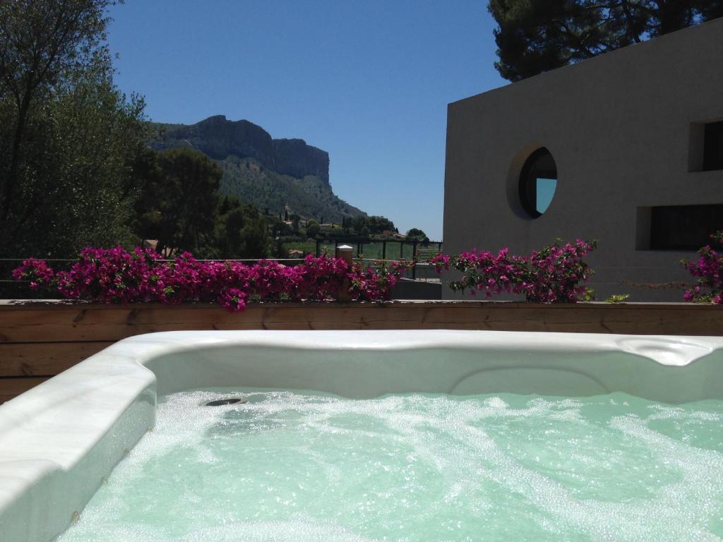 a hot tub in a backyard with purple flowers at BY Cassis chambre privée dans maison familiale in Cassis