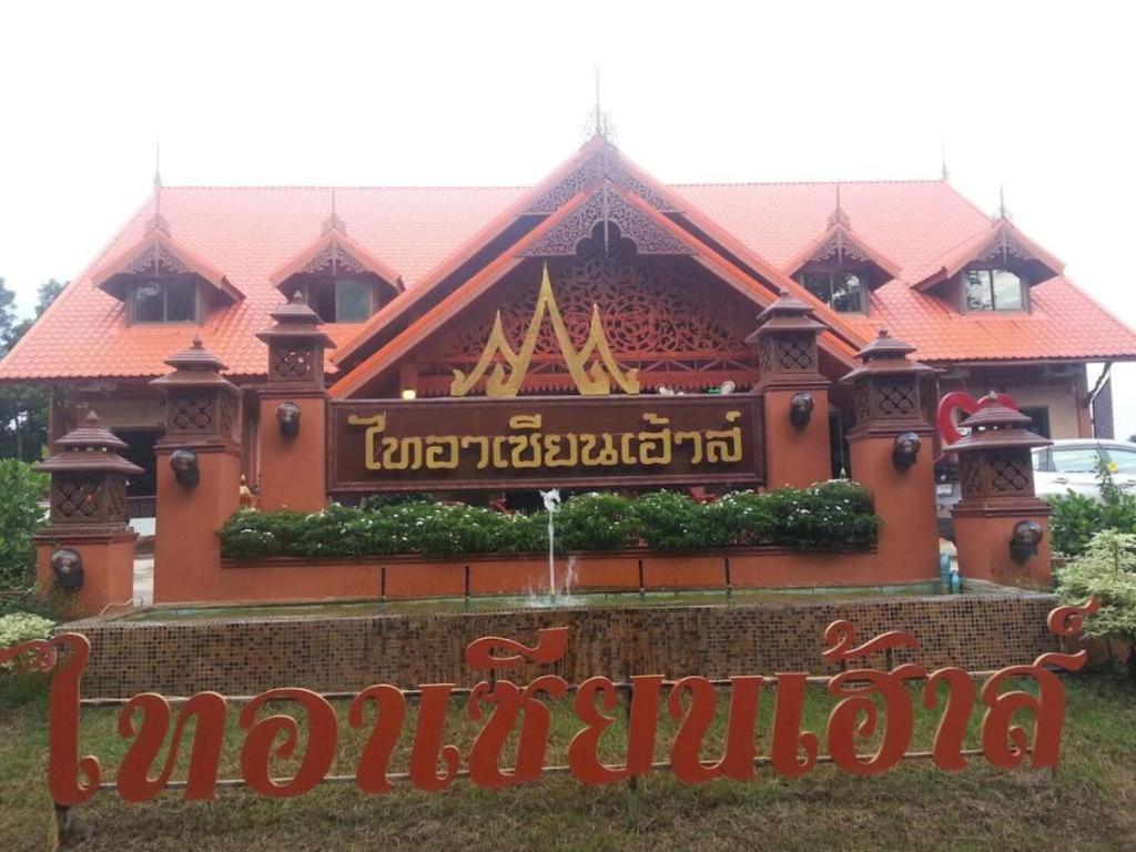 a building with a sign in front of it at Tai Asean House in Ban Kham Kling