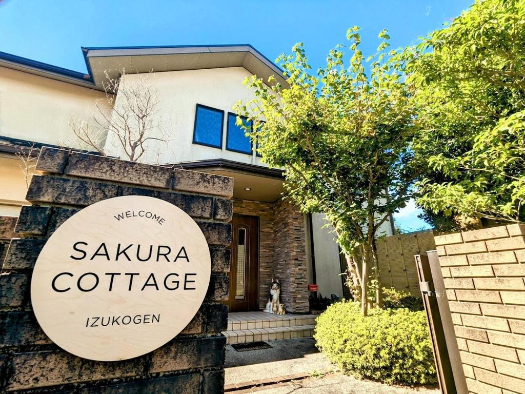 uma placa indicando uma cabana com sauna em frente a uma casa em SAKURA Cottage Izukogen em Ito