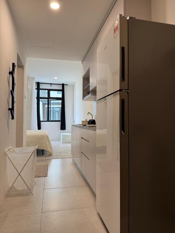 a kitchen with a black refrigerator in a room at StayCO - D'Millenia Residences - Studio Unit in Kuching